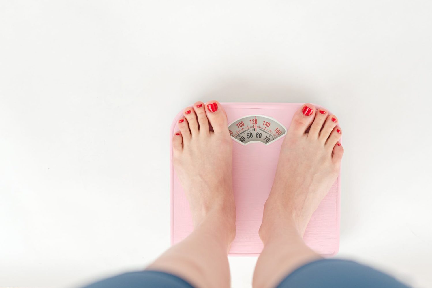 woman weighing on scales in studio