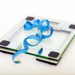 blue tape measuring on clear glass square weighing scale