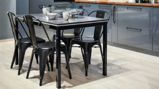 white ceramic mug on black dining table with four chair set